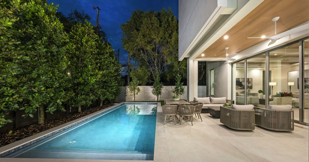 Modern home with a pool at dusk